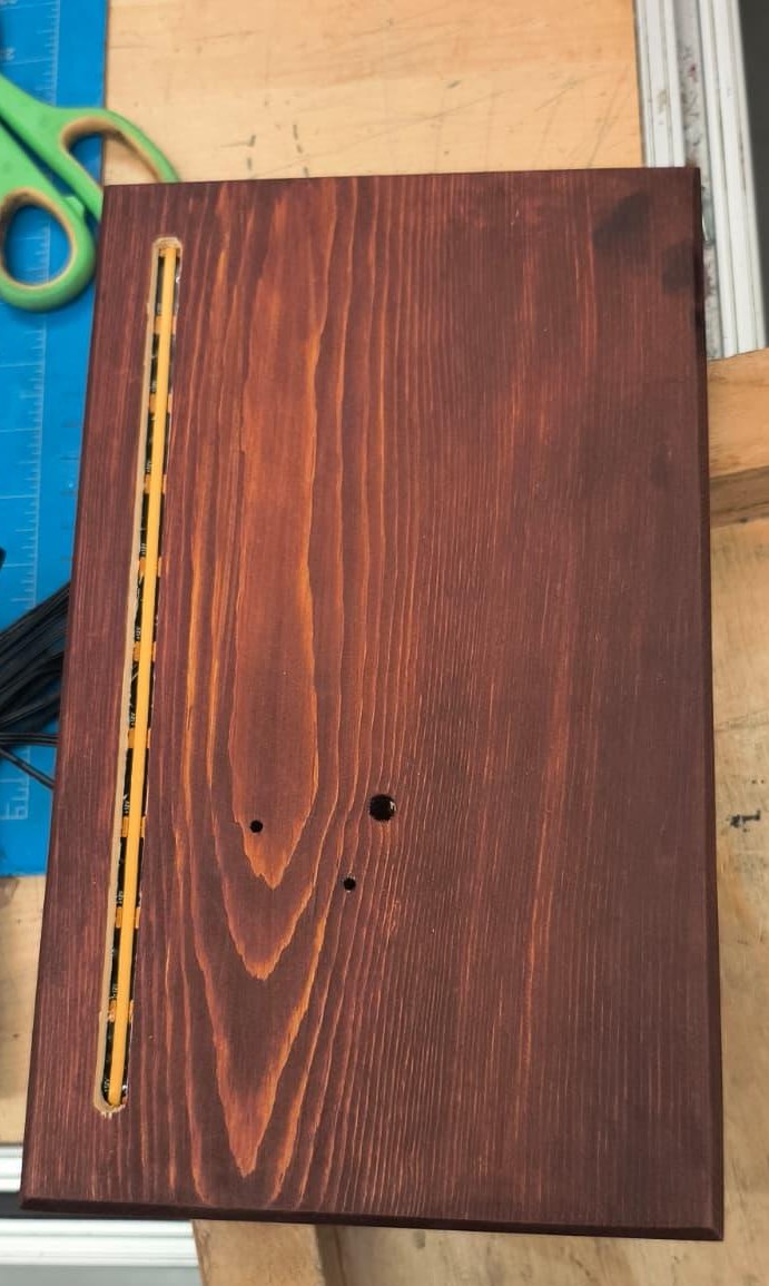 The wooden base, stained, with a long channel routed along one edge for the light strip.