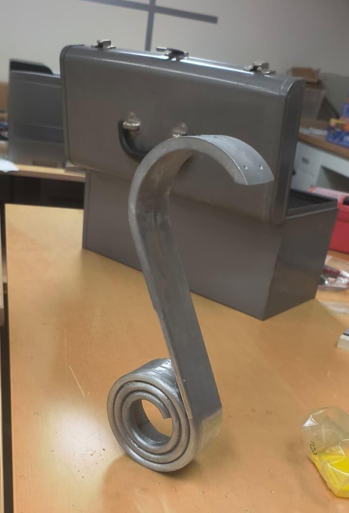 The curved arm on the machine part-way through the corner rounding operation, its edge half broken.