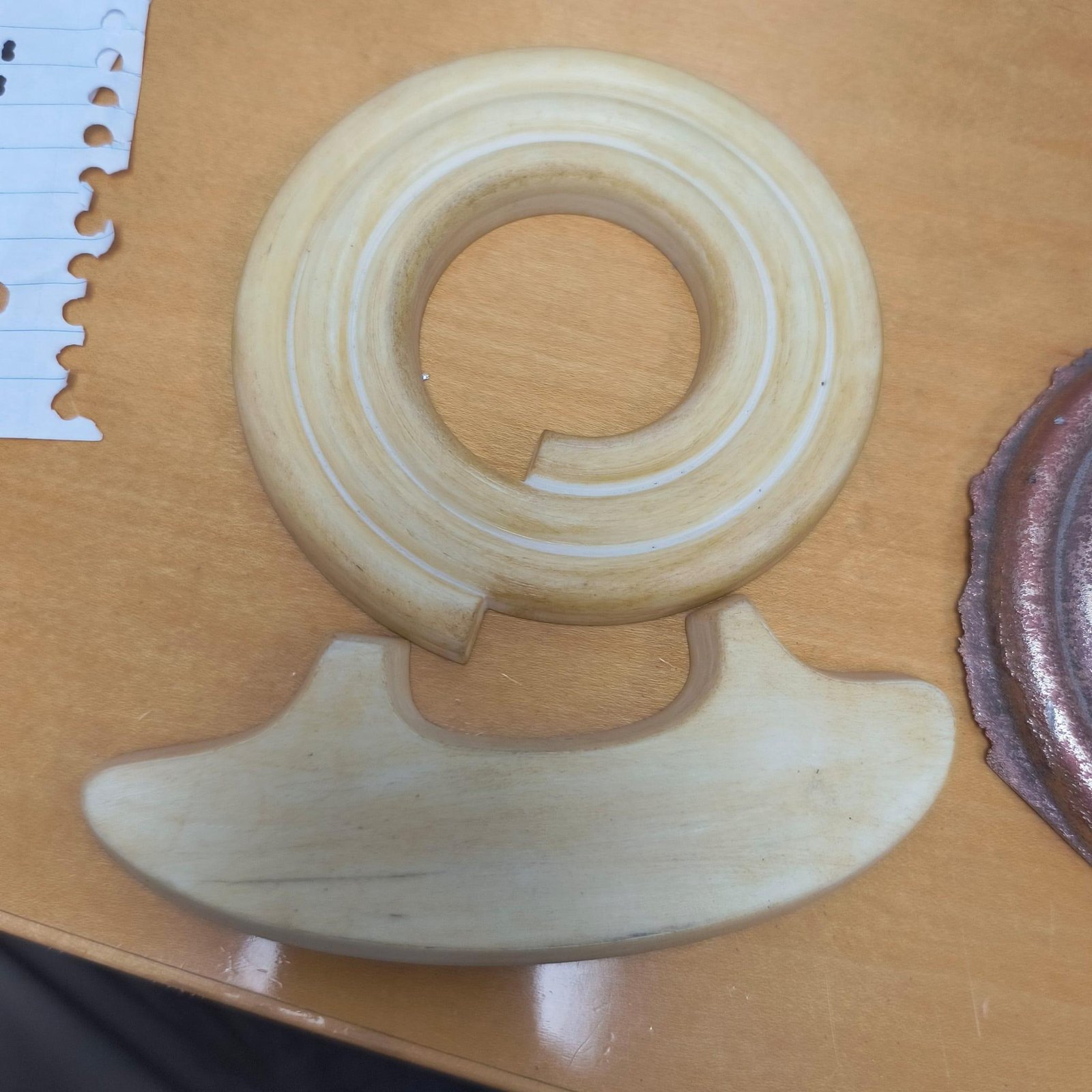 The casting pattern for the coil, in white, on a bench.