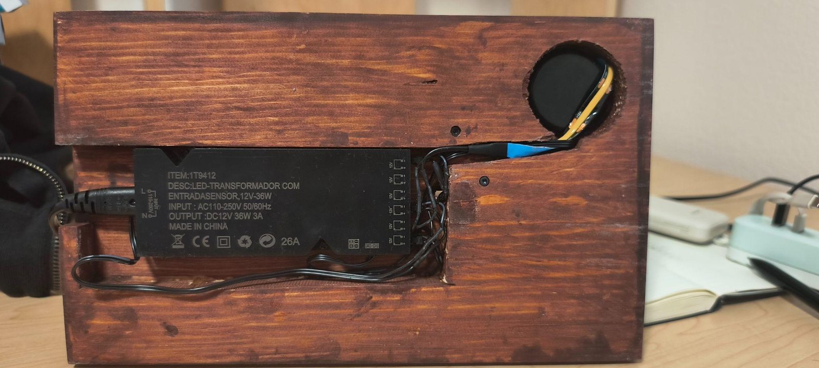 The underside of the base with the transformer in a routed pocket and the cable runs taped down.